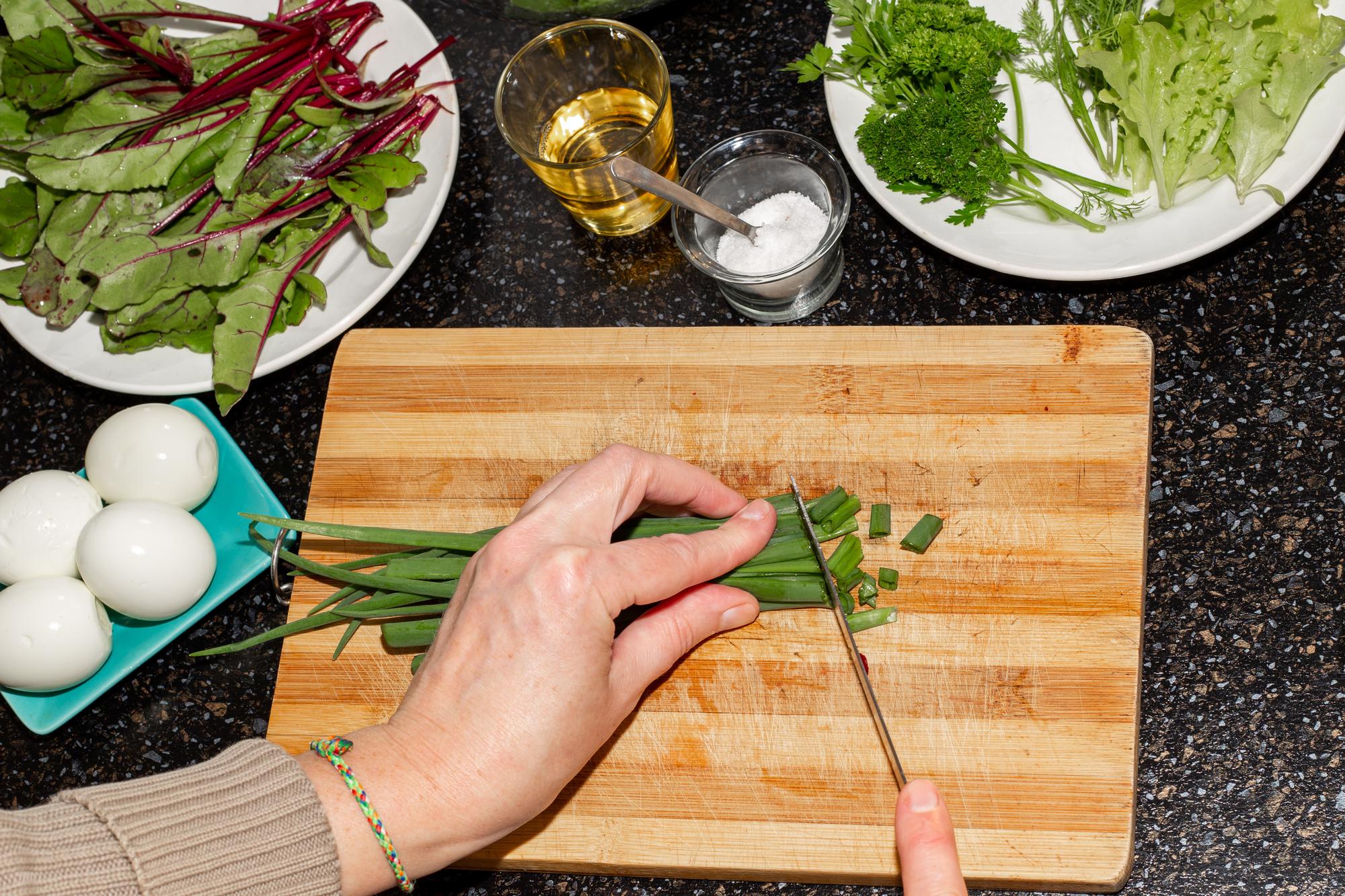 Chef arranging herbs on a wooden board